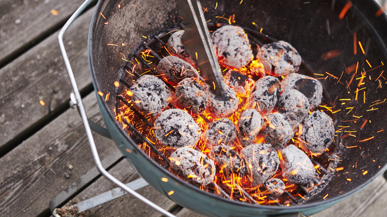 charcoal burning in grill on wooden deck