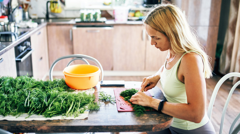 woman chopping fresh herbs