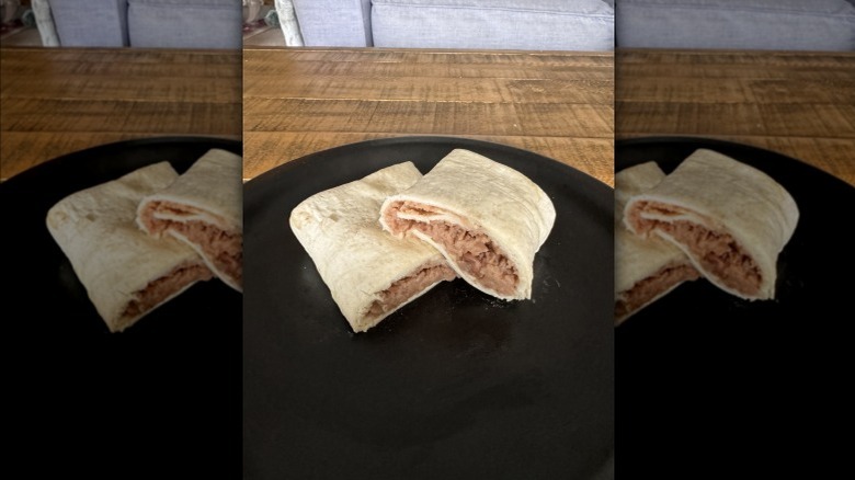 Aldi's Casa Mamita bean & cheese burrito on black plate and wooden table