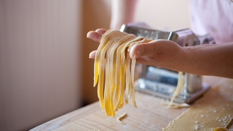 Home cook holding cut pasta