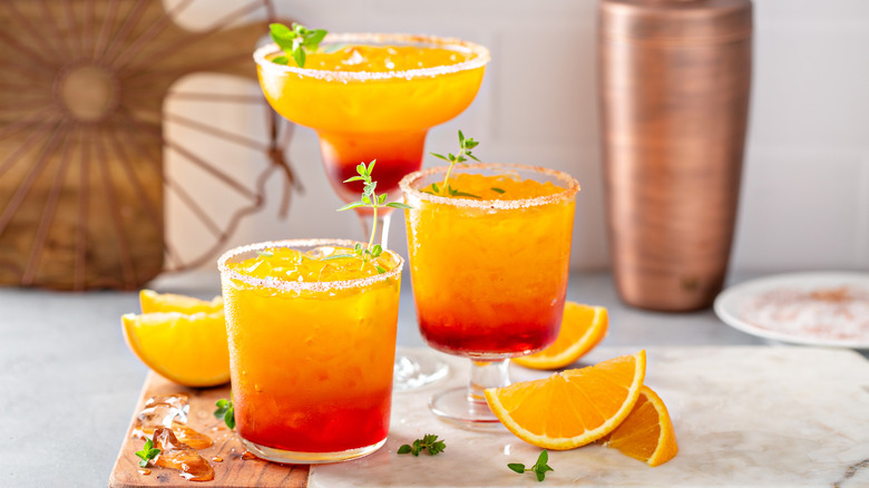 Three glasses with orange liquid