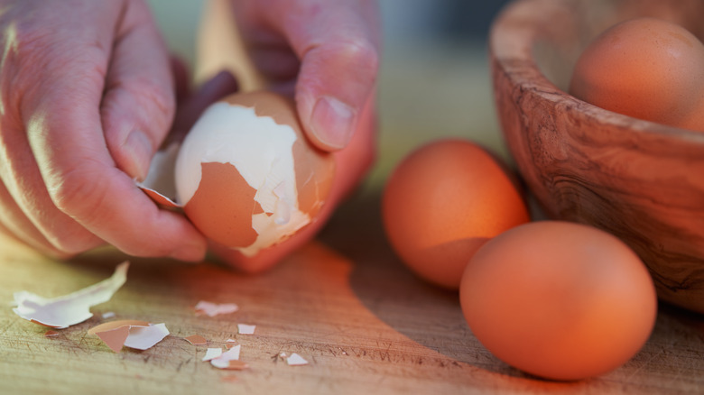 Hand peeling hard boiled eggs