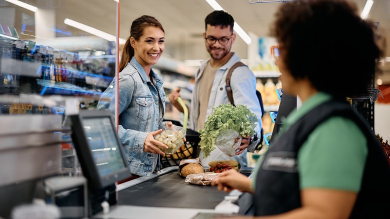 couple smiling at supermarket checkout