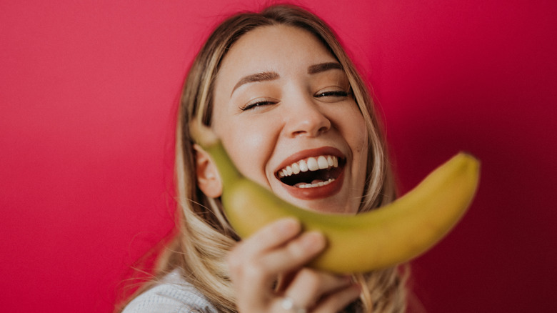 Woman smiling with banana