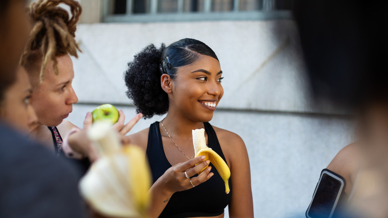 Woman eating banana after exercise