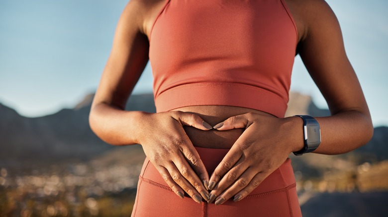 Woman making heart on stomach