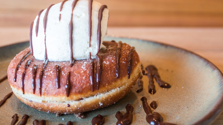 Donut topped with ice cream and fudge