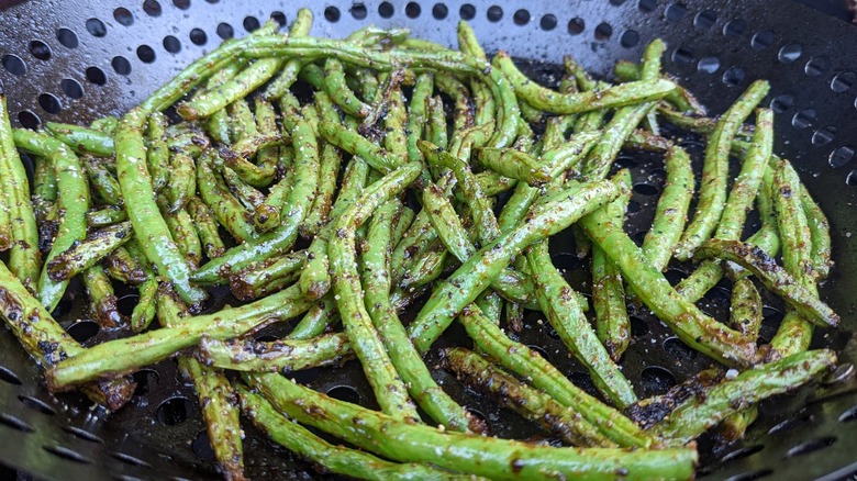 Seasoned green beans in grill basket