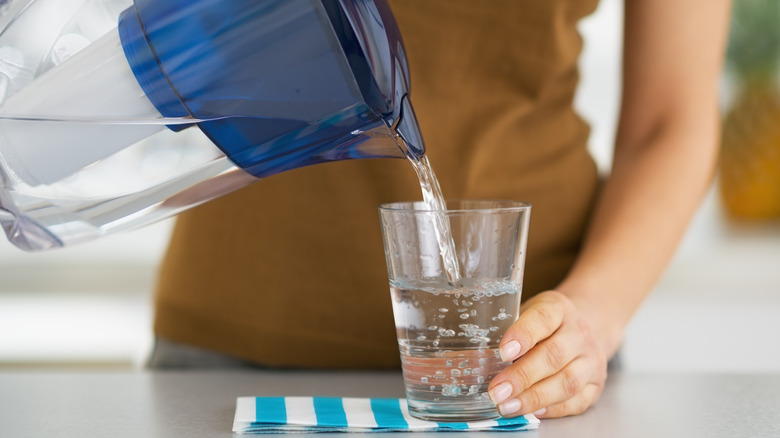 Woman pouring liquid from a filtered pitcher