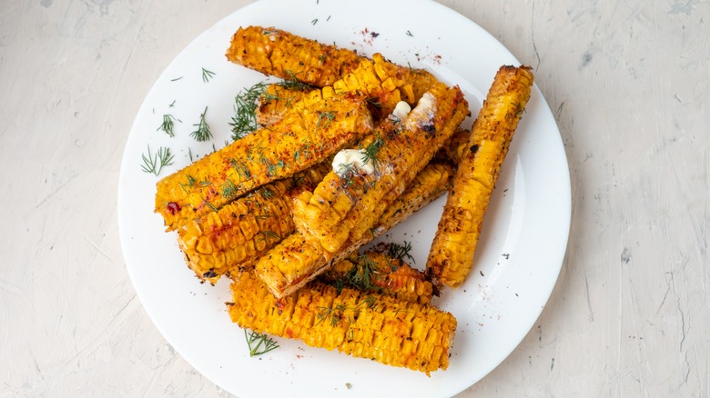 A plate of corn topped with spices