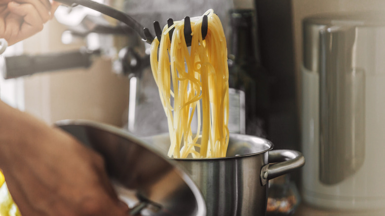 scooping pasta out of pot