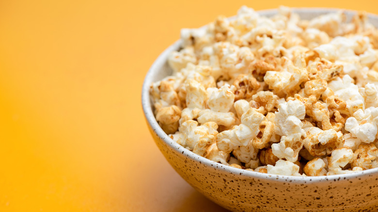 A popcorn bowl against a yellow background