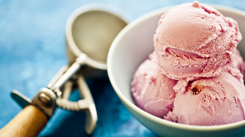 strawberry ice cream in bowl with scoop