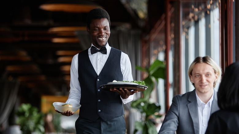 Restaurant server carrying tray and bowl