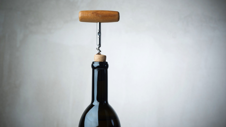 a corkscrew inserted into the cork of a bottle of wine