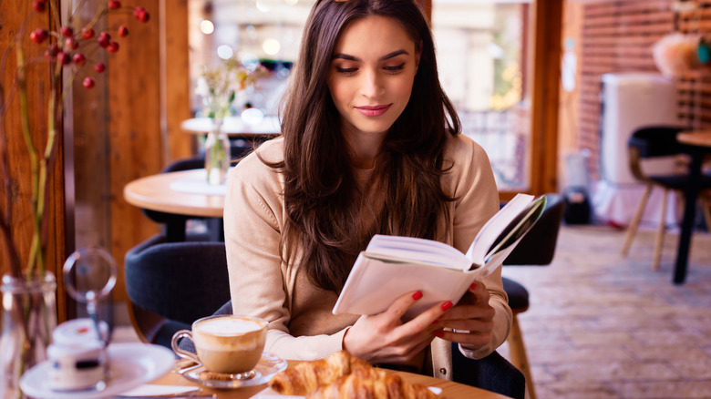 Woman reading book in cafe