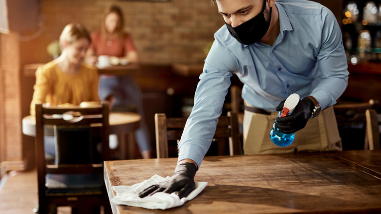 Waiter cleaning table