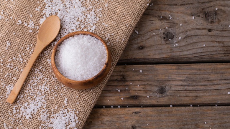 Sea salt in bowl, with spoon and jute fabric