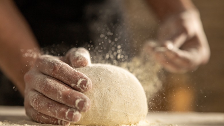 hands flouring dough