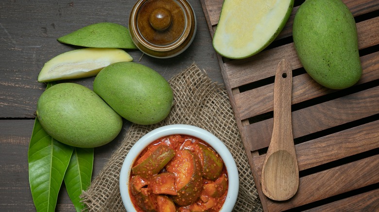 Top-down view of a bowl of pickled mango and green mangoes