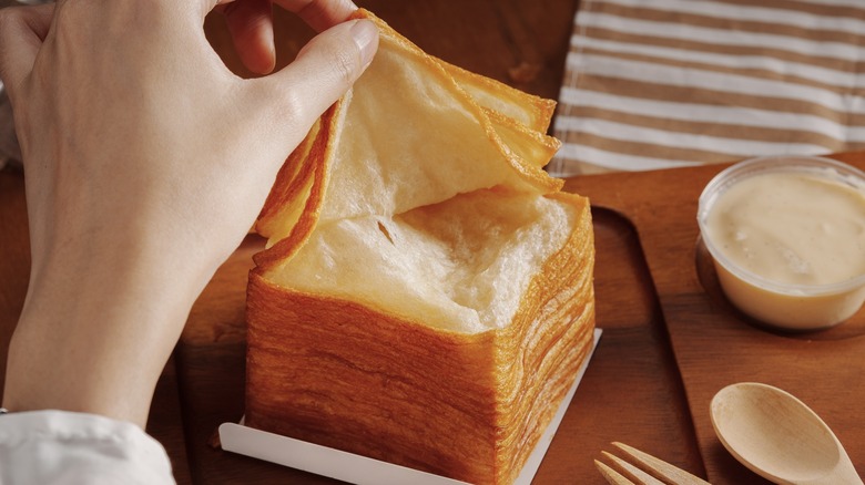 hand pulling layers off tissue bread