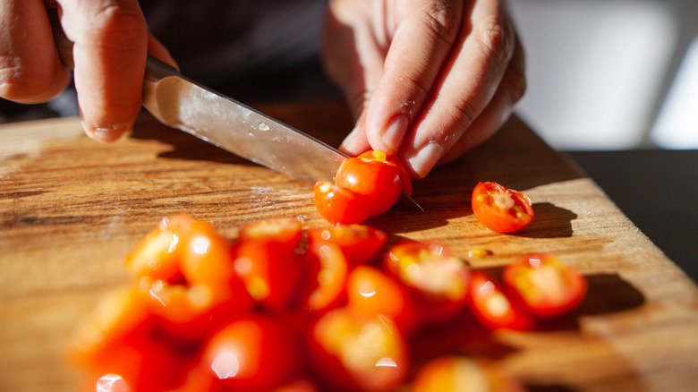 slicing cherry tomatoes in half