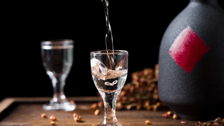 Two glasses of rice wine next to a bottle