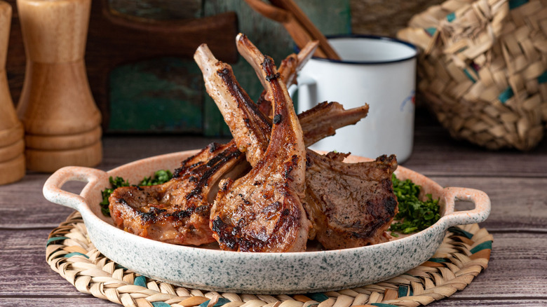 Lamb chops on a plate in a rustic home kitchen setting