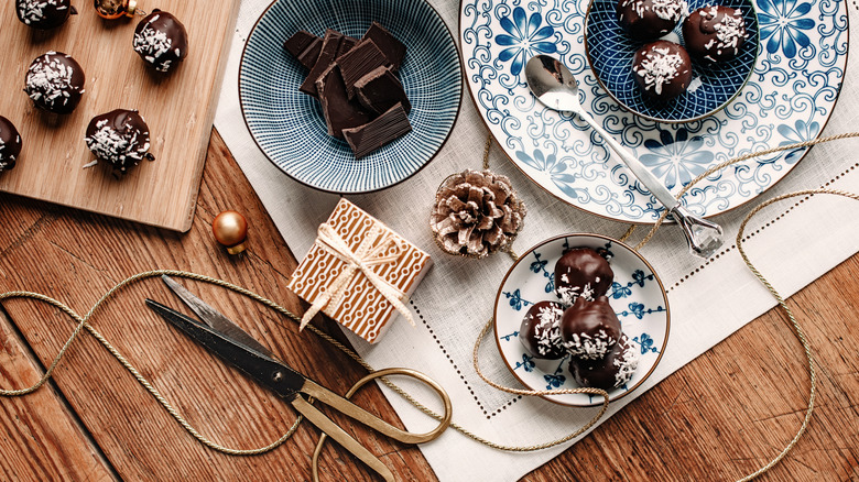 Homemade chocolates in bowls with holiday gift wrap