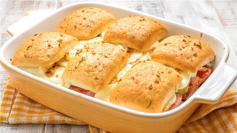 Ham and cheese dinner roll bake in yellow ceramic dish