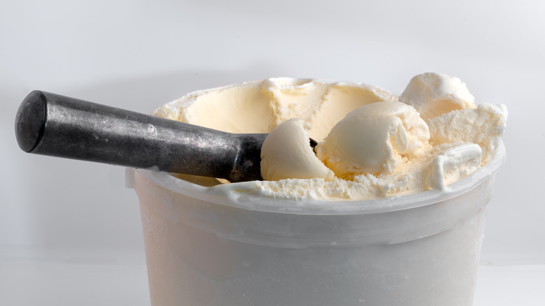 tub of vanilla ice cream with scooper