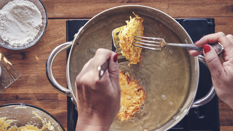 frying fritters in pot filled with oil