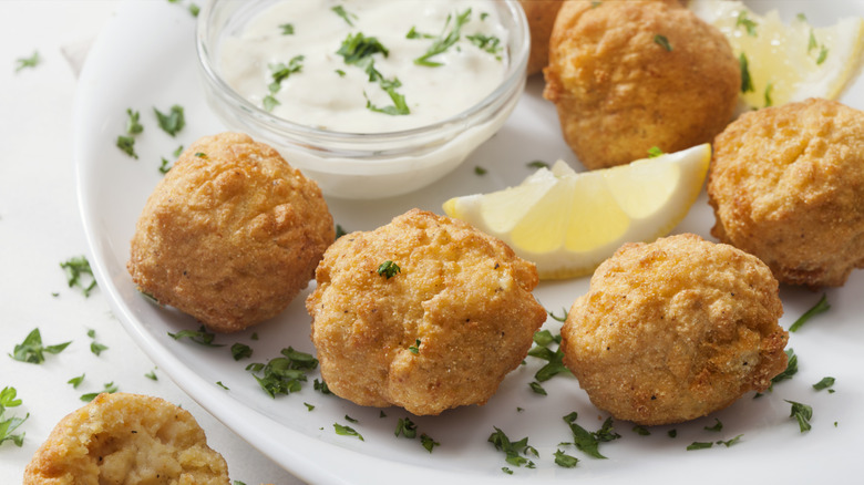 Souther style hush puppies served with a creamy dip and lemon wedges