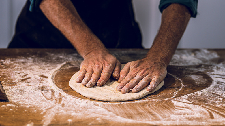 Flattening a piece of pizza dough