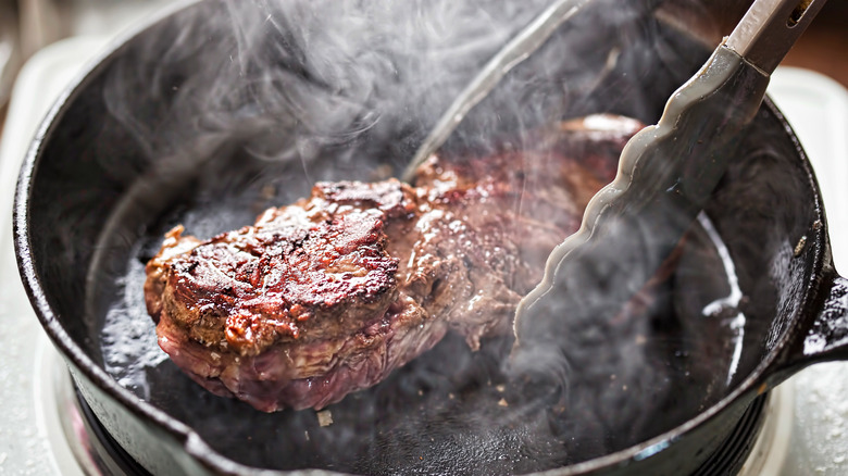 Pan-frying meat with tongs