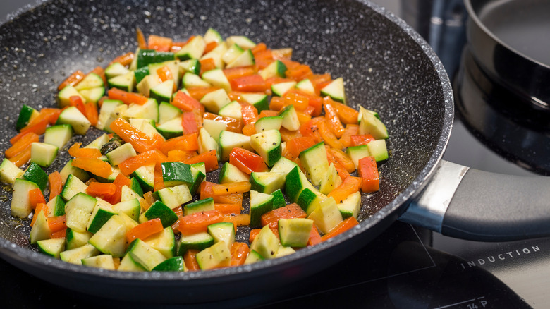 Sautéing vegetables coated in oil