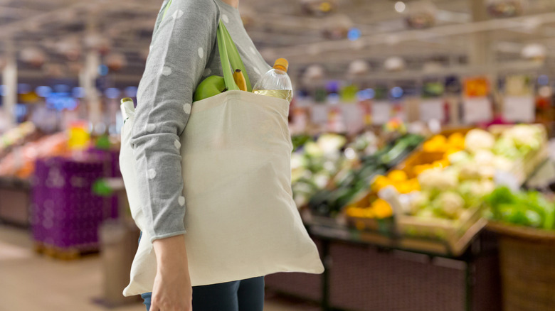Woman holding reusable bag at grocery store