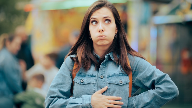 Woman holding stomach looking hungry