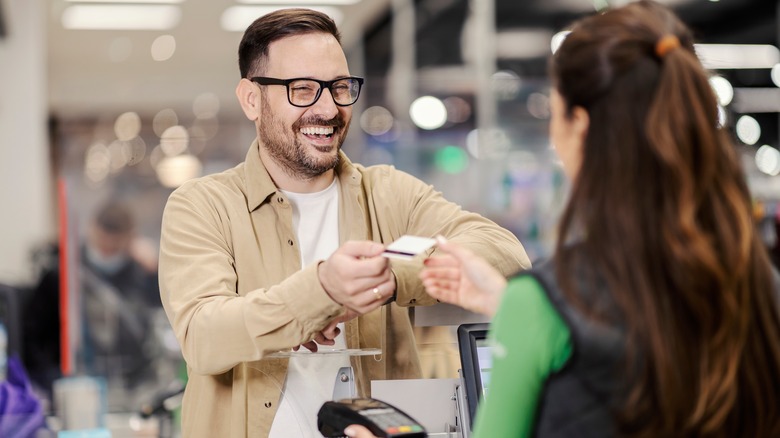 Man handing card to cashier