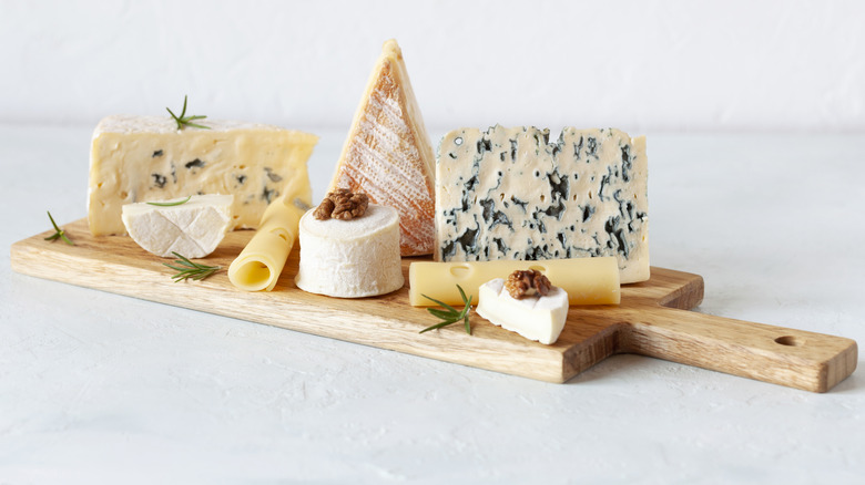 Soft cheeses on wooden board