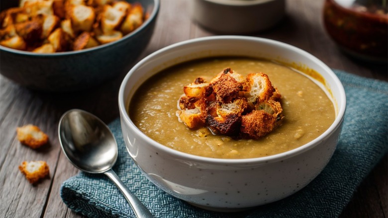 croutons placed in a bowl of lentil soup