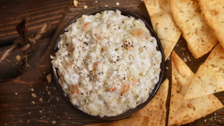 Crab dip on a board with chips