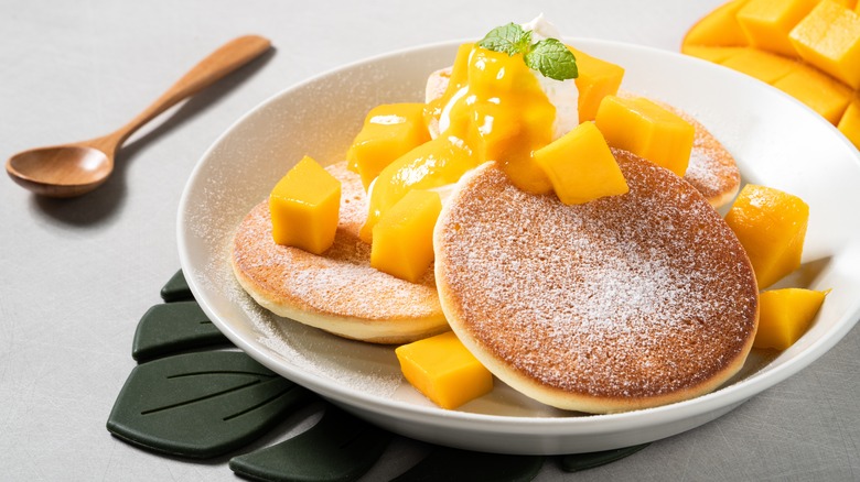 Mango topping on powdered sugar pancakes with mint