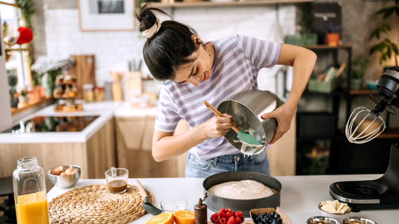 Woman pouring cake batter into a pan