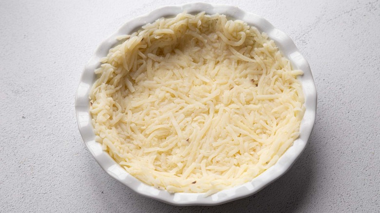 hash browns pressed into a pie dish