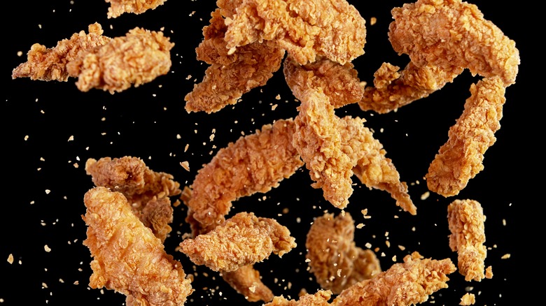 Fried chicken strips on black background