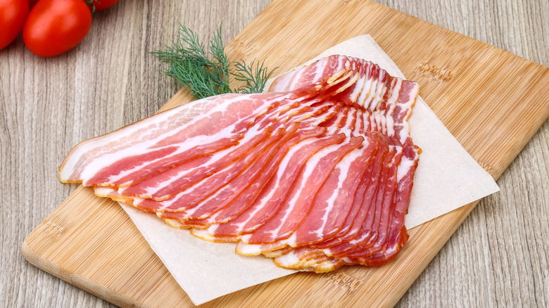 Raw bacon on cutting board