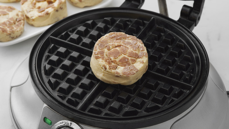 canned cinnamon roll dough on waffle iron