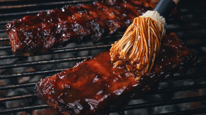 Spareribs being brushed with sauce