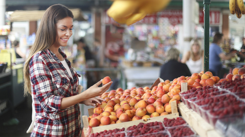 Woman choosing peaches